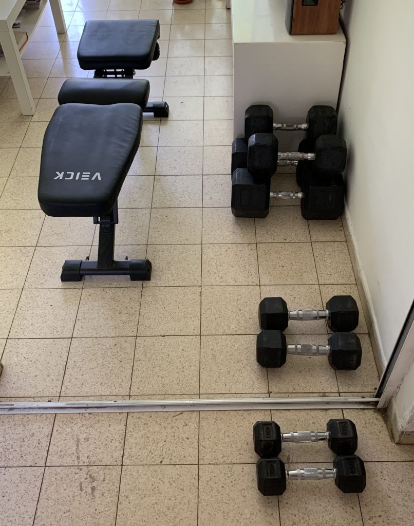 תמונת קונספט כהה של מותג אולימפוס הממחישה מינימליזם בחדר הכושר, תרגילי בסיס מרוכבים וחישול חוסן מנטלי.